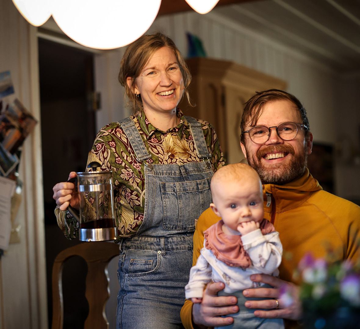 En kvinna och en man med ett litet barn i ett kök.